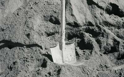 Heap of fine grey sand with a shovel — stock photo