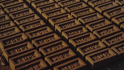 Rows of red clay bricks laid out on the ground